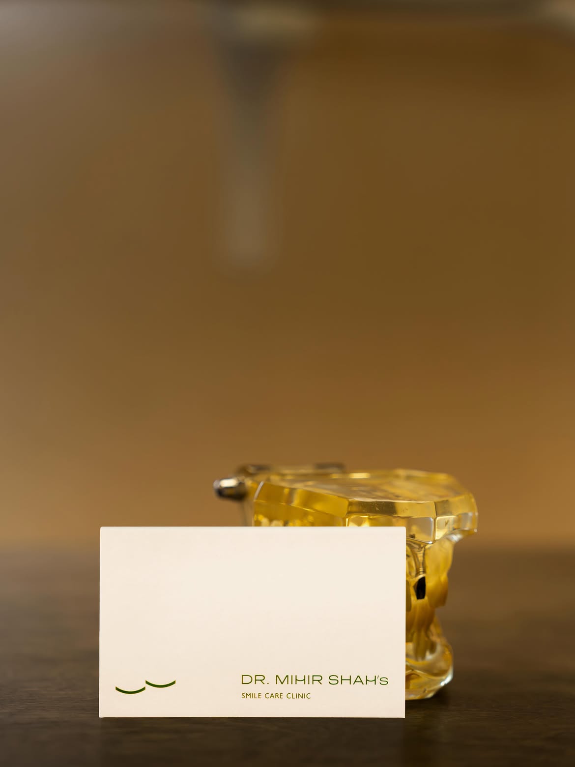 Dr. Mihir Shah's Smile Care Clinic business card beside a dental model