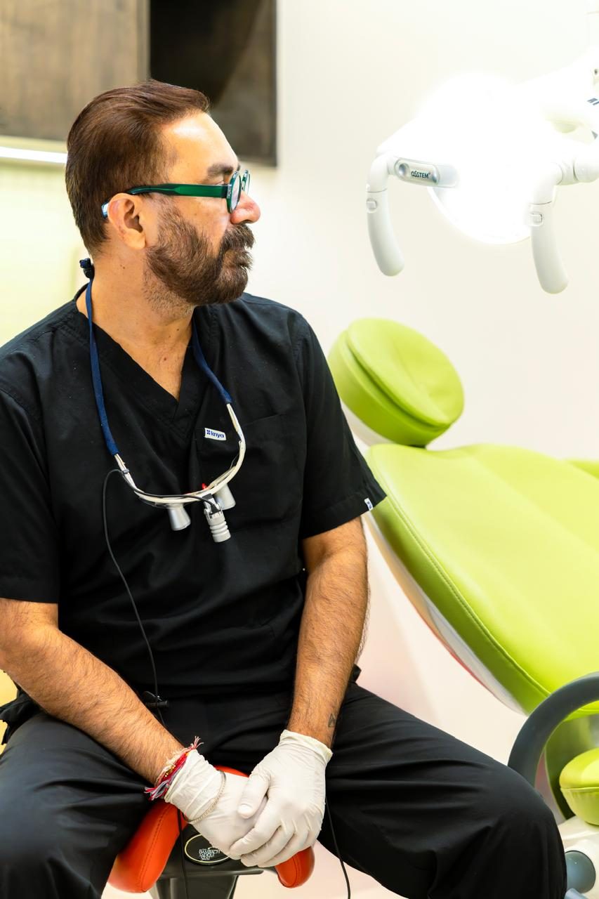 Dr. Mihir Shah with surgical loupes beside the treatment chair